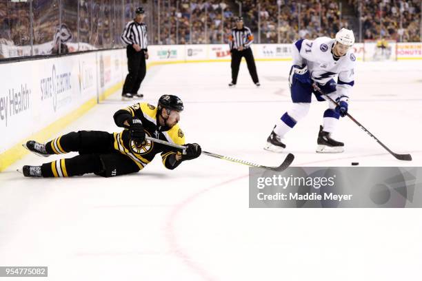 Brad Marchand of the Boston Bruins slides after the puck with pressure from Anthony Cirelli of the Tampa Bay Lightning during the third period of...