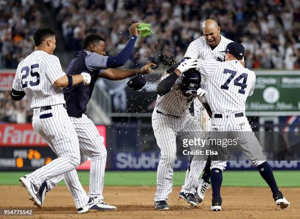 Miguel Andujar of the New York Yankees is showered by teammates Aaron Hicks,Luis Severino,Gleyber Torres and Ronald Torreyes of the New York Yankees...