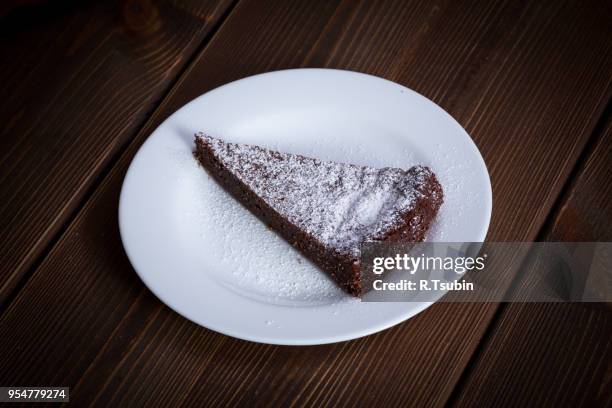 chocolate cake slice on white dish and wooden background - butter tart stock pictures, royalty-free photos & images