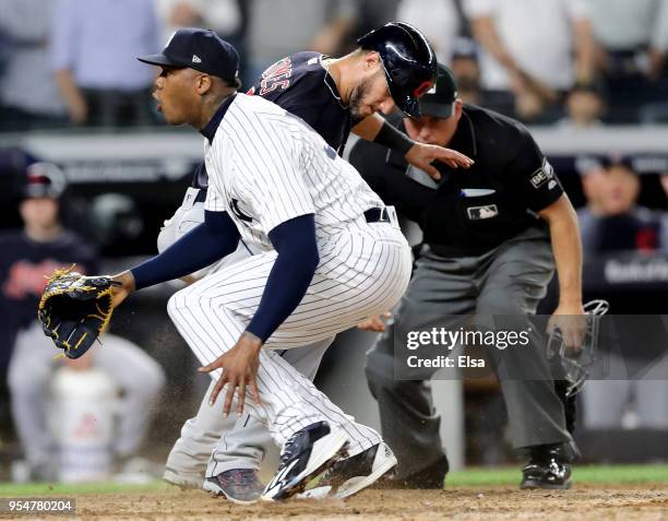 Yan Gomes of the Cleveland Indians scores on a wild pitch to teammate Jason Kipnis as Aroldis Chapman of the New York Yankees reacts after trying to...