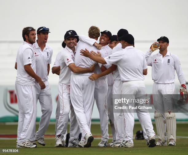 Graeme Swann of England and his team-mates congratulate Stuart Broad on taking the wicket of AB de Villiers of South Africa for 2 runs during day...