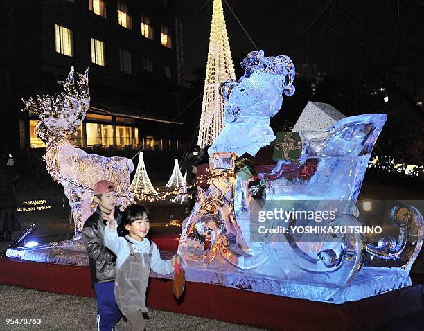 Children rund by illuminated ice sculptures shaped as reindeer in the garden of Tokyo's Takanawa Prince Hotel on December 24, 2009. AFP PHOTO /...