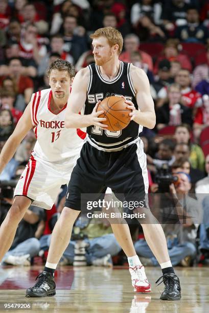 Matt Bonner of the San Antonio Spurs moves the ball against David Andersen of the Houston Rockets during the game on November 27, 2009 at the Toyota...