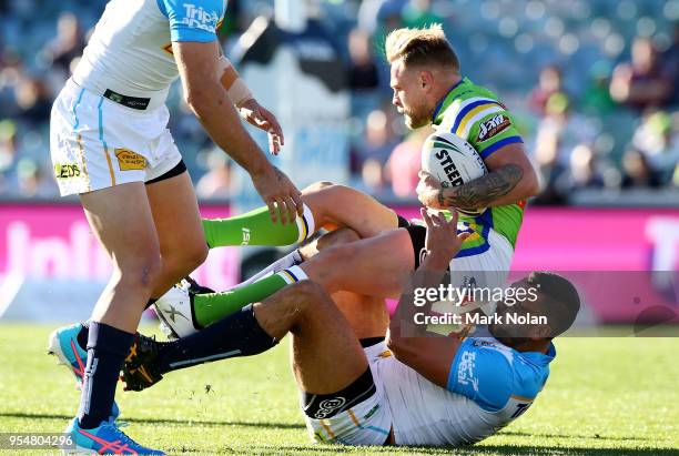 Blake Austin of the Raiders is tackled during the round nine NRL match between the Canberra Raiders and the Gold Coast Titans at GIO Stadium on May...