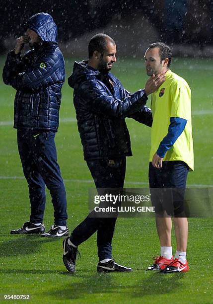 Barcelona´s coach talks with midfielder Andres Iniesta during a training session at Ciutat Esportiva Joan Gamper near Barcelona on December 29, 2009....