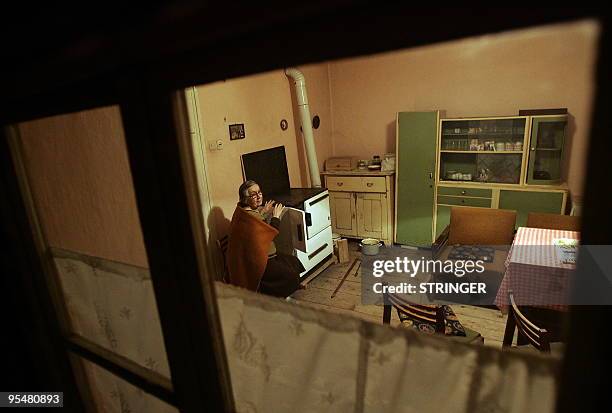 An elderly Croatian Neda Milanovic warms herself near the stove, as temperatures fall below minus 15 degrees Celsius in the village of Darda, close...