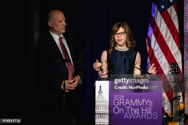 John Poppo, Chair of the Board for The Recording Academy stands by, as Recording artist Lisa Loeb speaks, at The Recording Academy's Grammys on the...