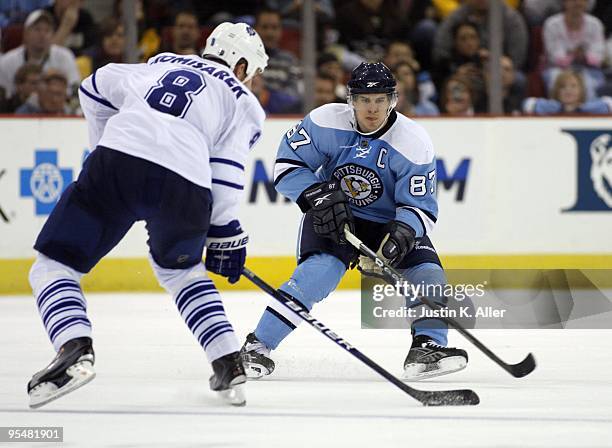 Sidney Crosby of the Pittsburgh Penguins skates against Mike Komisarek of the Toronto Maple Leafs at Mellon Arena on December 27, 2009 in Pittsburgh,...