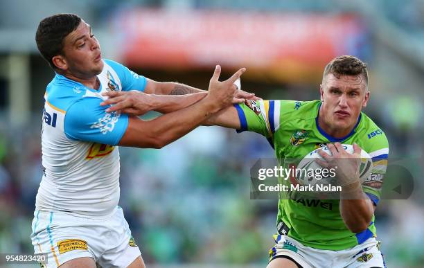 Jack Wighton of the Raiders palms off the defence during the round nine NRL match between the Canberra Raiders and the Gold Coast Titans at GIO...