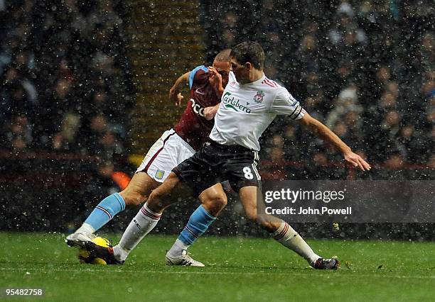 Steven Gerrard of Liverpool goes in on Luke Young of Aston Villa during the Barclays Premier League match between Aston Villa and Liverpool at Villa...