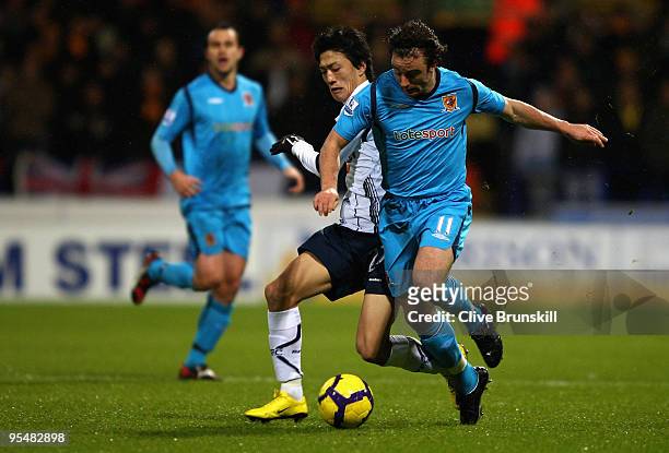 Stephen Hunt of Hull City holds off a challenge from Chung-Yong Lee of Bolton Wanderers during the Barclays Premier League match between Bolton...