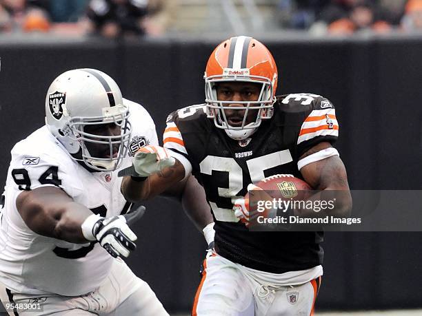 Running back Jerome Harrison of the Cleveland Browns returns a kickoff as defensive lineman William Joseph of the Oakland Raiders reaches for him...