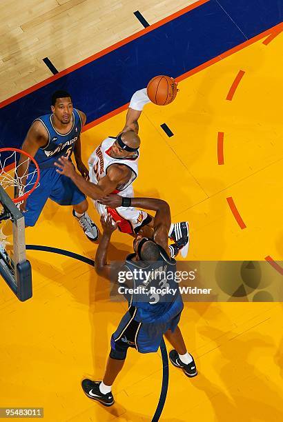 Corey Maggette of the Golden State Warriors puts up a shot between Dominic McGuire and Brendan Haywood of the Washington Wizards during the game on...