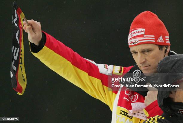 Werner Schuster head coach of Germany lifts the flag for the start during the FIS Ski Jumping World Cup event at the 58th Four Hills Ski Jumping...