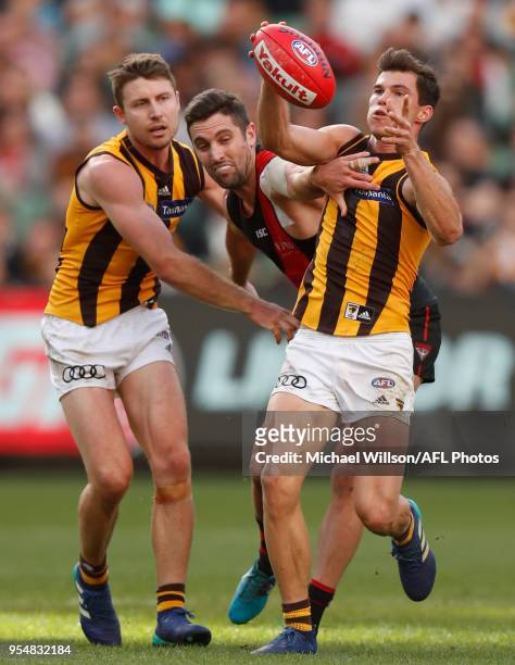 Liam Shiels of the Hawks, David Myers of the Bombers and Jaeger O'Meara of the Hawks compete for the ball during the 2018 AFL round seven match...