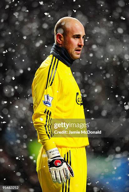 Goalkeeper Pepe Reina of Liverpool tries to keep warm in the snow during the Barclays Premier League match between Aston Villa and Liverpool at Villa...