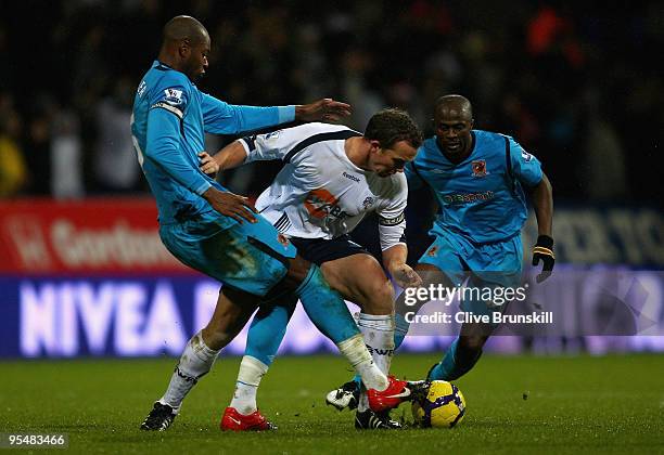 Kevin Davies of Bolton Wanderers attempts to move past Anthony Gardner of Hull City during the Barclays Premier League match between Bolton Wanderers...