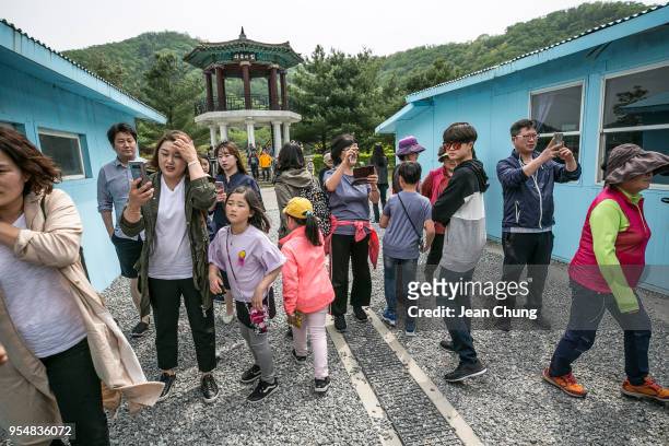 Visitors take pictures at a mock Panmunjeom on May 5, 2018 in Namyangju, South Korea. Namyangju Studios is a film-making studio known for housing a...