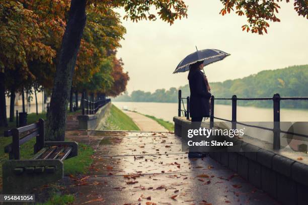 vrouw stond op de regen - white and black women and umbrella stockfoto's en -beelden