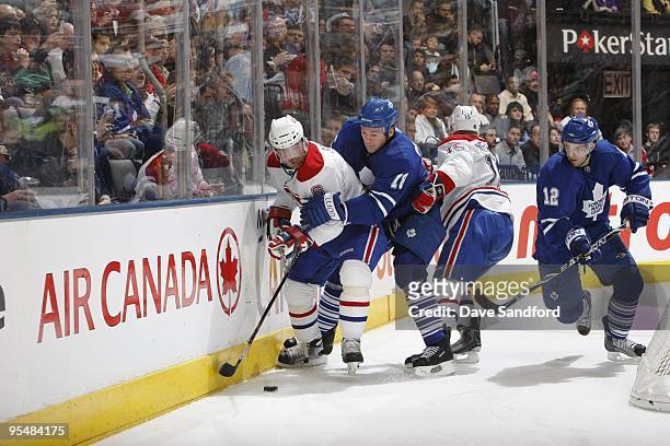 Wayne Primeau and Lee Stempniak of the Toronto Maple Leafs look to play the puck away from Jaroslav Spacek of the Montreal Canadiens during their NHL...