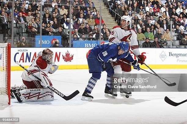 Ed Jovanovski of the Phoenix Coyotes defends Wayne Primeau of the Toronto Maple Leafs as goaltender Ilya Bryzgalov of the Phoenix Coyotes looks for...
