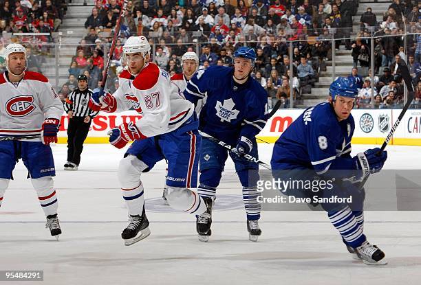 Max Pacioretty of the Montreal Canadiens skates on the forecheck behind Mike Komisarek of the Toronto Maple Leafs during their NHL game at the Air...