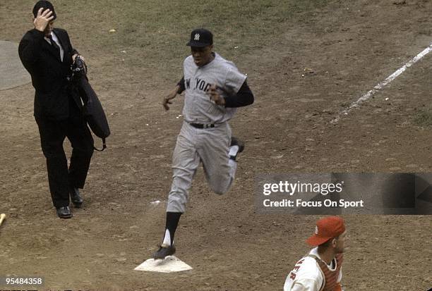 Catcher Elston Howard of the New York Yankees scores a run against the St. Louis Cardinal during the World Series, October 1964 at Busch Stadium in...