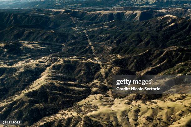 power lines crossing forest from above - hollister foto e immagini stock