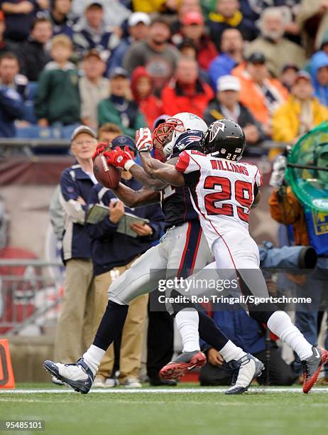 Randy Moss of the New England Patriots attempts to make a catch as Brian Williams of the Atlanta Falcons blocks on September 27, 2009 at Gillette...