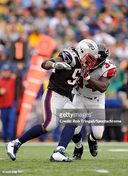 Ovie Mughelli of the Atlanta Falcons blocks Linebacker Pierre Woods of the New England Patriots during the game on September 27, 2009 at Gillette...