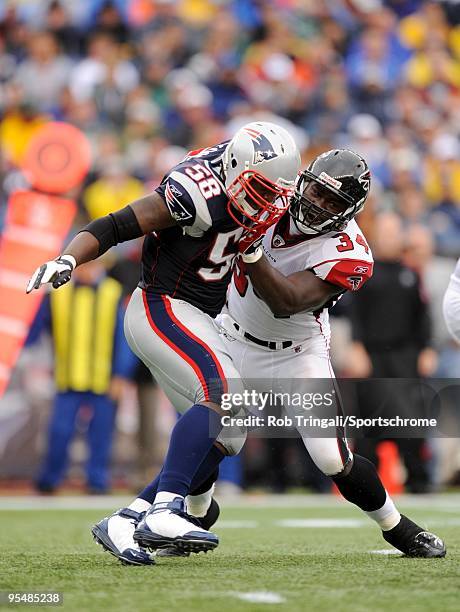 Ovie Mughelli of the Atlanta Falcons blocks Linebacker Pierre Woods of the New England Patriots during the game on September 27, 2009 at Gillette...