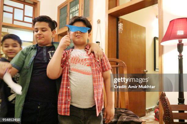 young boys having fun in a party with face mask on - cute pakistani boys fotografías e imágenes de stock