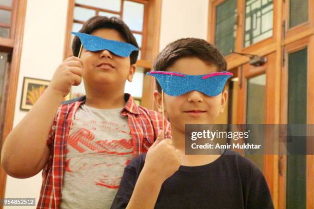 young boys having fun in a party with face mask on - cute pakistani boys fotografías e imágenes de stock