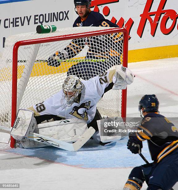 Marc Andre Fleury of the Pittsburgh Penguins slides across the crease to make a save in front of Tim Connolly and Jason Pominville of the Buffalo...