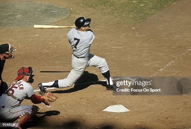 Outfielder Mickey Mantle of the New York Yankees swings and watches the flight of his ball against the St. Louis Cardinal during the World Series,...