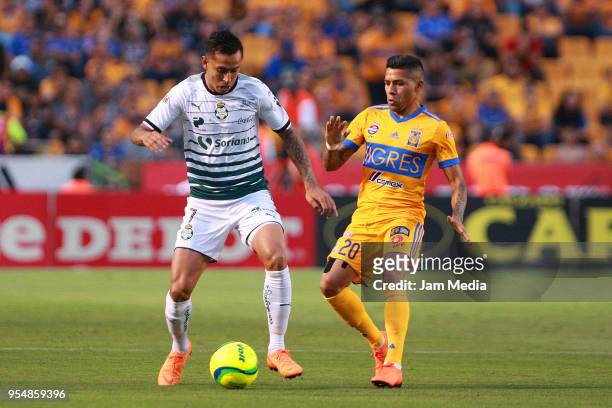 Jesús Isijara of Santos and Javier Aquino of Tigres compete for the ball during the quarter finals first leg match between Tigres UANL and Santos...