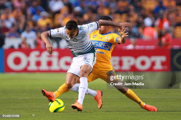 Jesús Isijara of Santos and Javier Aquino of Tigres fight for the ball during the quarter finals first leg match between Tigres UANL and Santos...