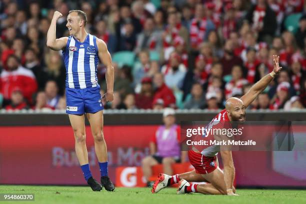 Billy Hartung of the Kangaroos celebrates kicking a goal as Jarrad McVeigh of the Swans appeals for a touch during the round seven AFL match between...