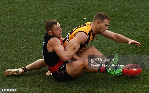 Devon Smith of the Bombers and Tom Mitchell of the Hawks compete for the ball during the round seven AFL match between the Essendon Bombers and the...