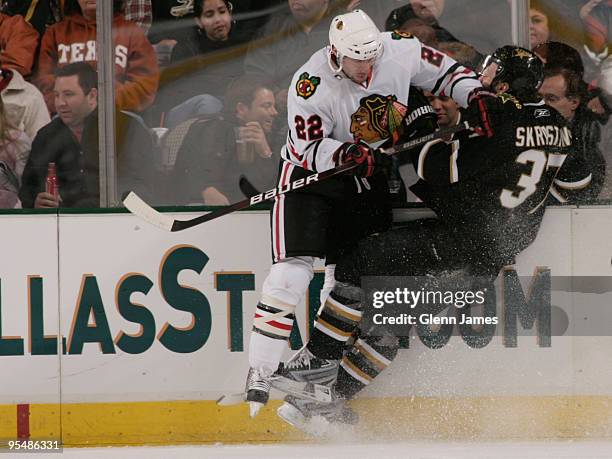 Karlis Skrastins of the Dallas Stars takes a hit from Troy Brouwer of the Chicago Blackhawks on December 29, 2009 at the American Airlines Center in...