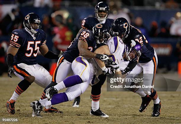 Jeff Dugan of the Minnesota Vikings is brought down by Danieal Manning and Hunter Hillenmeyer of the Chicago Bears as teammate Lance Briggs moves in...