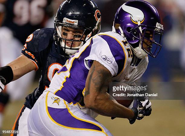 Hunter Hillenmeyer of the Chicago Bears tackles Percy Harvin of the Minnesota Vikings at Soldier Field on December 28, 2009 in Chicago, Illinois. The...