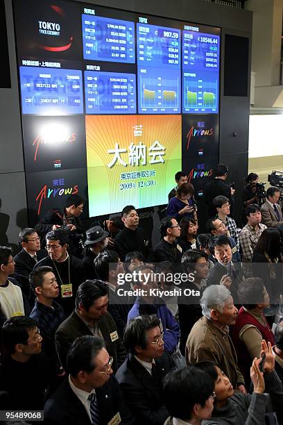 Visitors and representatives from securities firms attend the closing ceremony to mark the end of the year's trading at the Tokyo Stock Exchange on...