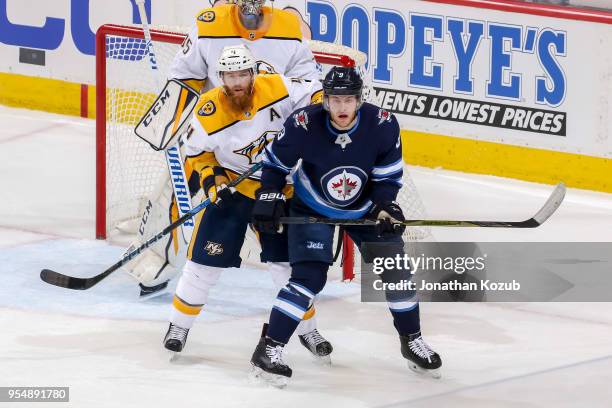Ryan Ellis of the Nashville Predators and Andrew Copp of the Winnipeg Jets battle for position as they keep their eyes on the play during second...