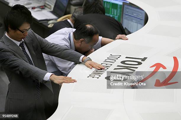 Dealers work on the last day of the year's trading at the Tokyo Stock Exchange on December 30, 2009 in Tokyo, Japan. The Nikkei Stock Average closed...