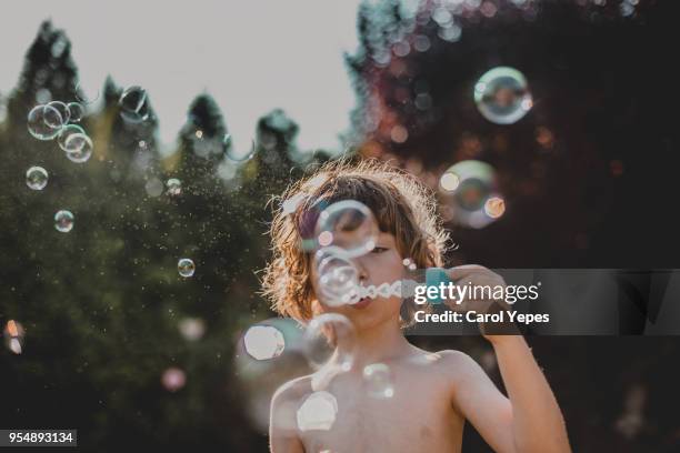 boy  making bubbles outdoor - bubble wand photos et images de collection