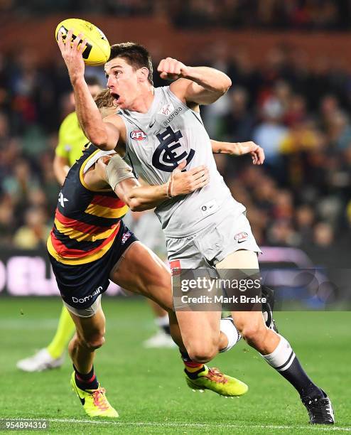 Matthew Kreuzer of the Blues handballs under pressure from Hugh Greenwood of the Adelaide Crows during the round seven AFL match between the Adelaide...