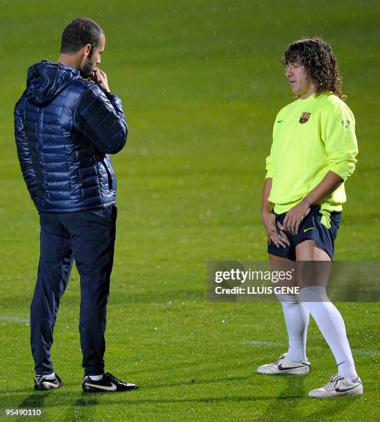Barcelona´s coach talks with captain Carles Puyol during a training session, at Ciutat Esportiva Joan Gamper near Barcelona on December 29, 2009. AFP...