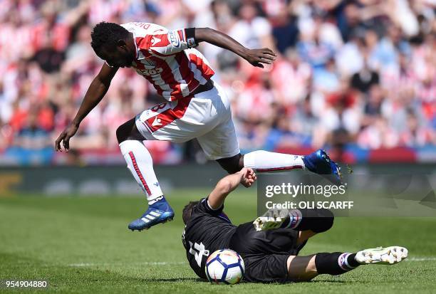 Crystal Palace's Serbian midfielder Luka Milivojevic vies with Stoke City's Senegalese striker Mame Biram Diouf during the English Premier League...