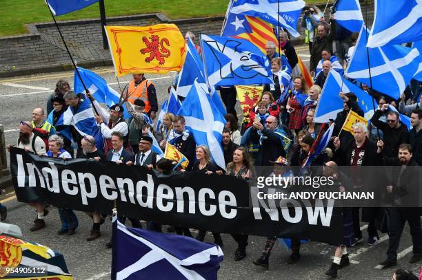Thousands of demonstrators carry Saltire flags, the national flag of Scotland, as they march in support of Scottish independence through the streets...